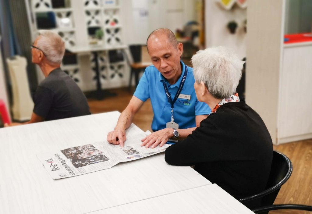 A Heart for Service: Francis reading a mandarin newspaper to an elder